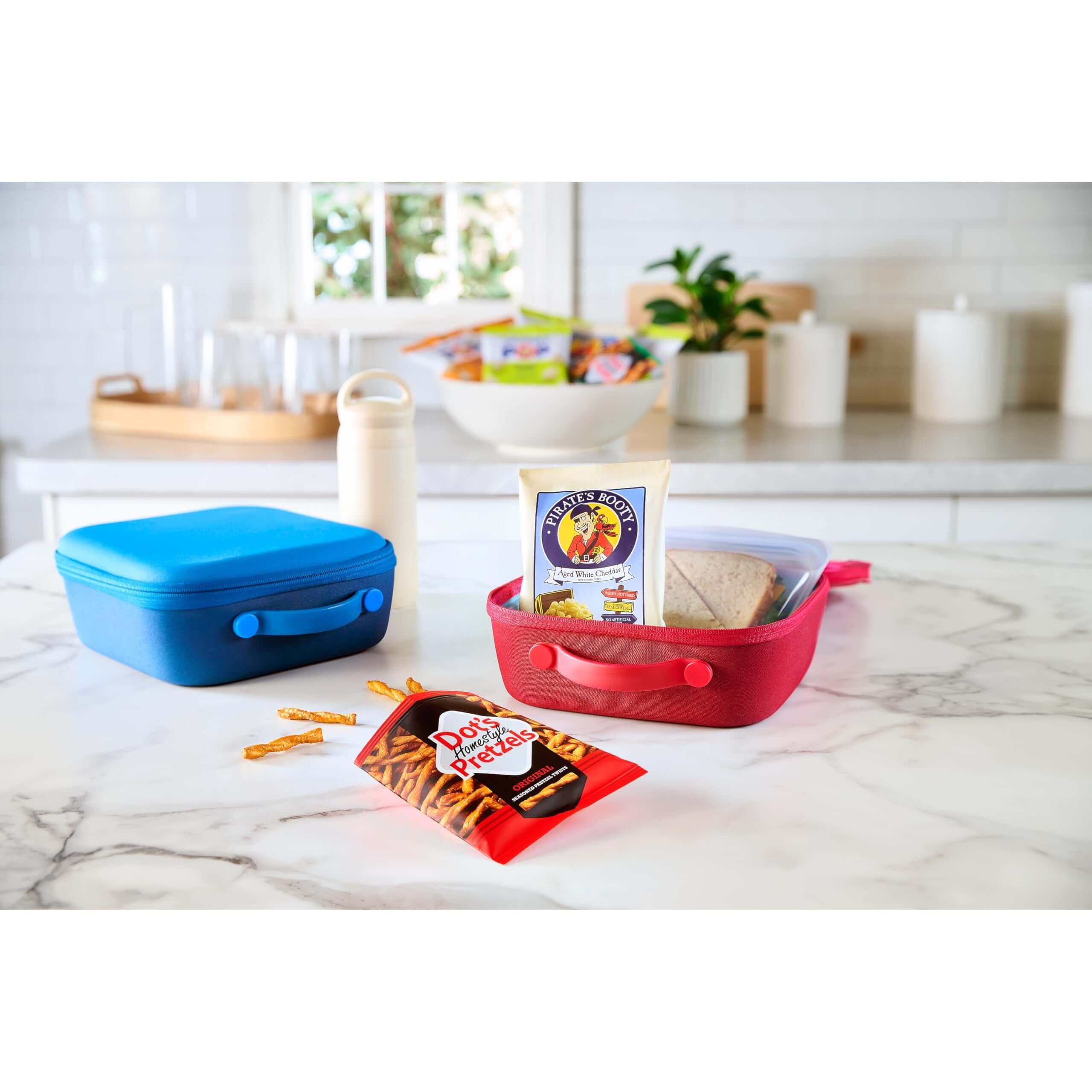 SkinnyPop Family Favorite Variety Pack - Colorful lunch containers with snacks on a kitchen counter.