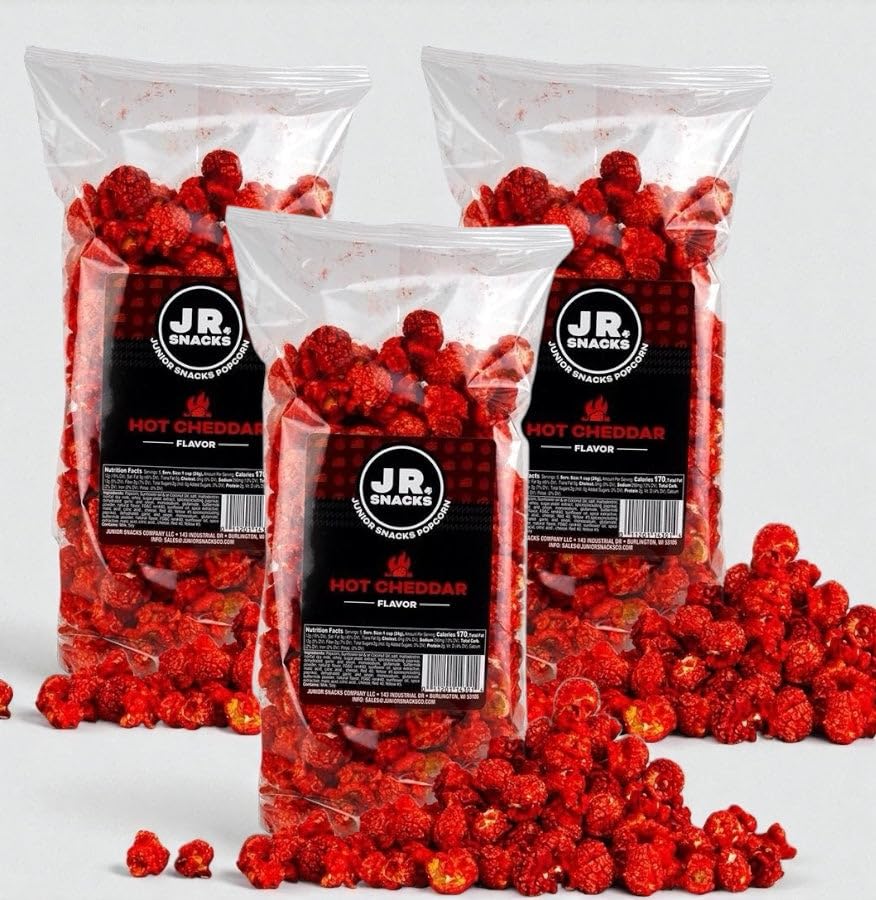 Hot Junior Snacks Co. Hot Cheddar bags filled with spicy cheddar popcorn on a gray background.