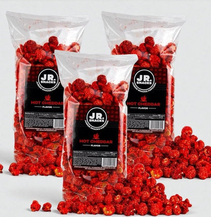 Hot Junior Snacks Co. Hot Cheddar bags filled with spicy cheddar popcorn on a gray background.