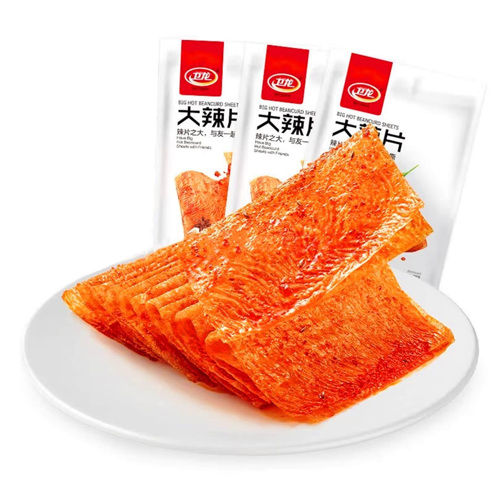 Chinese Spicy Latiao Gluten Strips on a white plate with packaging in the background.