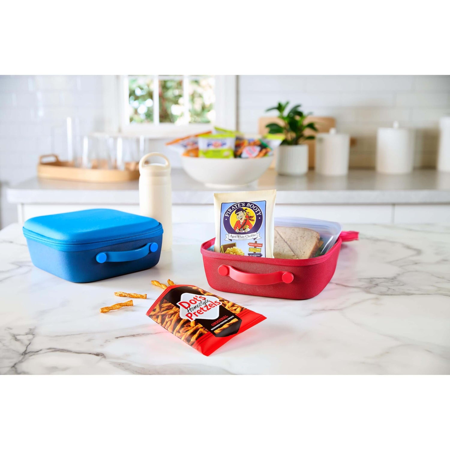 SkinnyPop Family Favorite Variety Pack - Colorful lunch containers with snacks on a kitchen counter.