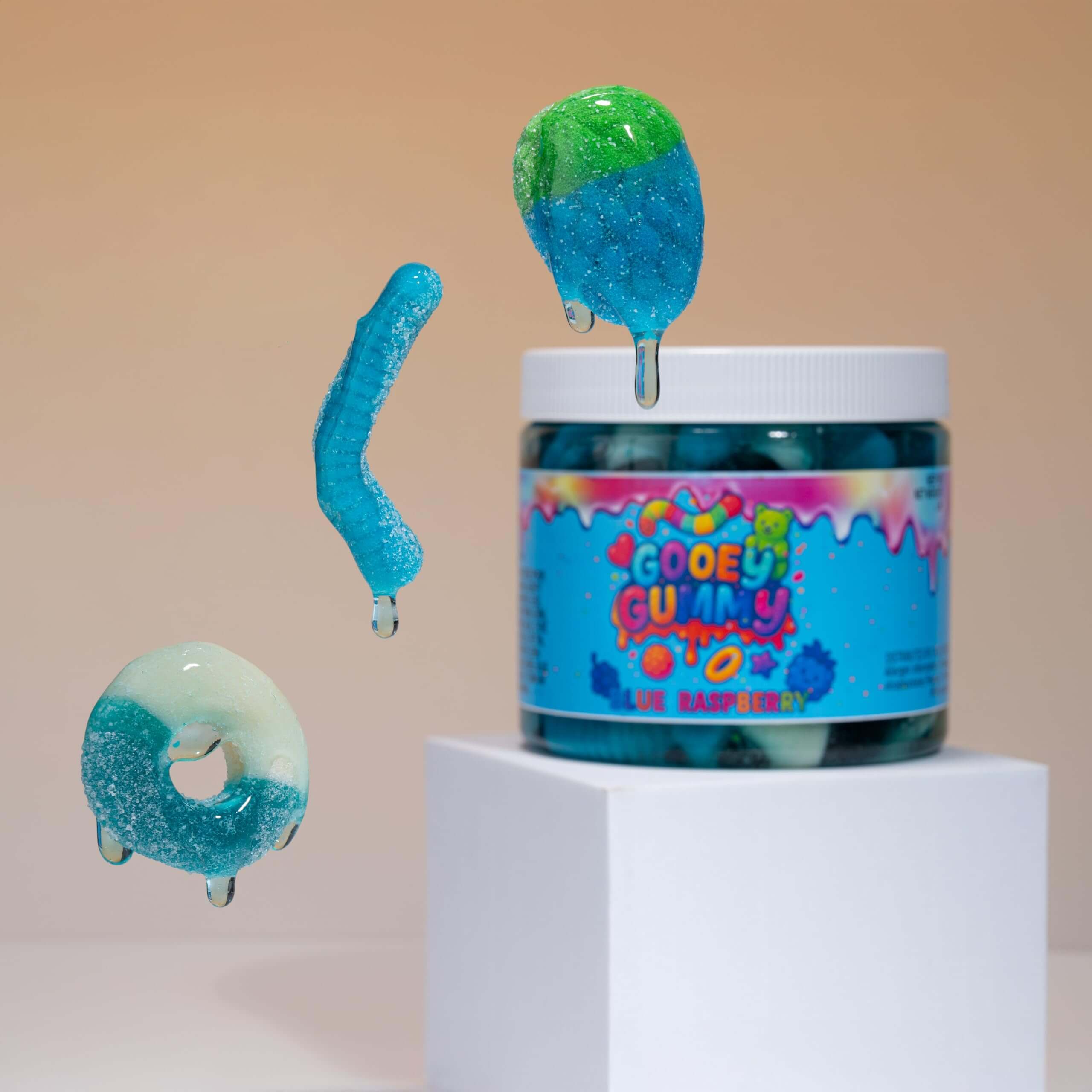 Viral Sour Gooey Gummies - Blue Raspberry candy jar with floating gummies on a pedestal.