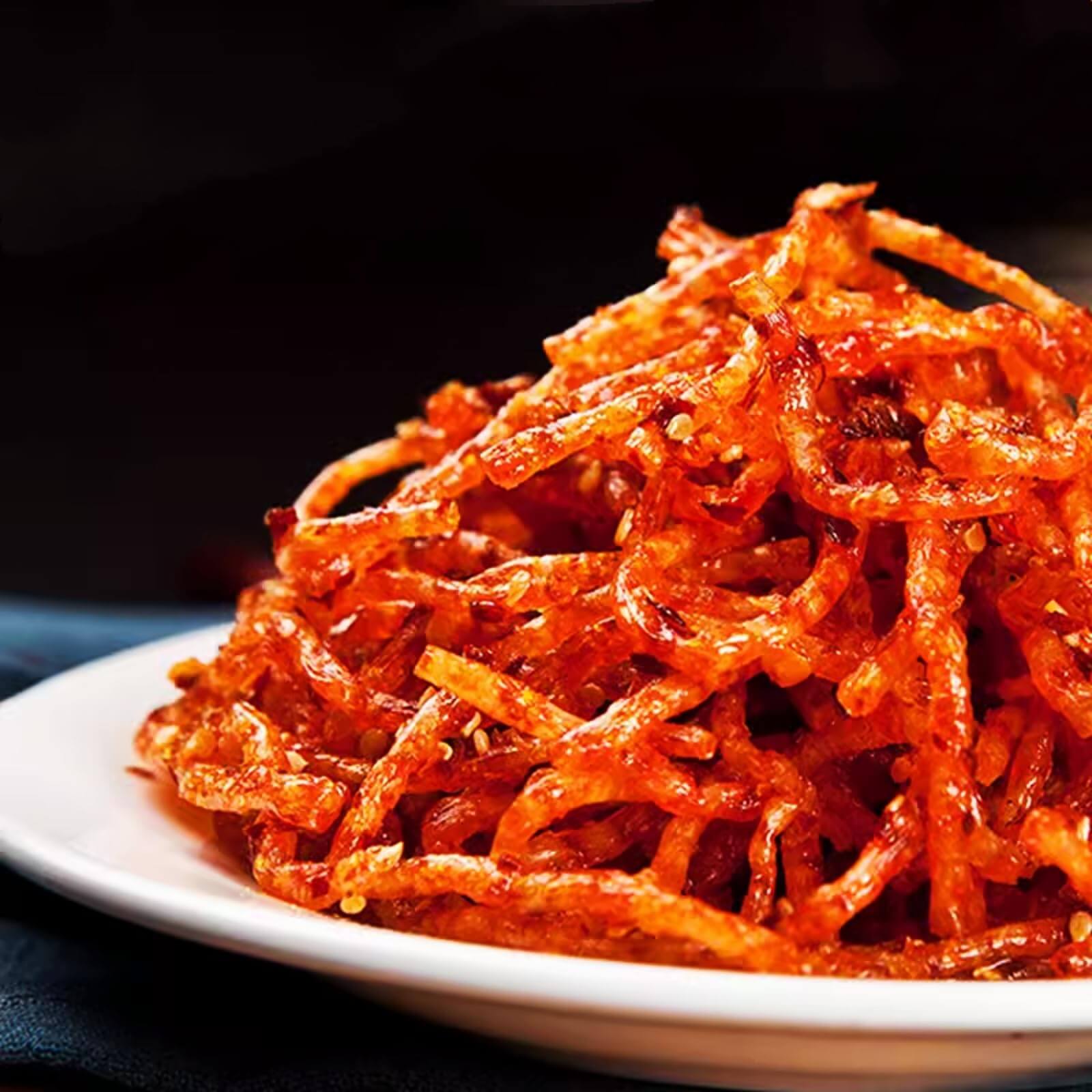 Chinese Spicy Latiao Gluten Strips served on a white plate, showcasing their vibrant red color and spicy texture.