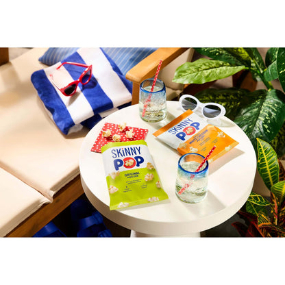 SkinnyPop Family Favorite Variety Pack featuring original and cheddar popcorn on a summer table.