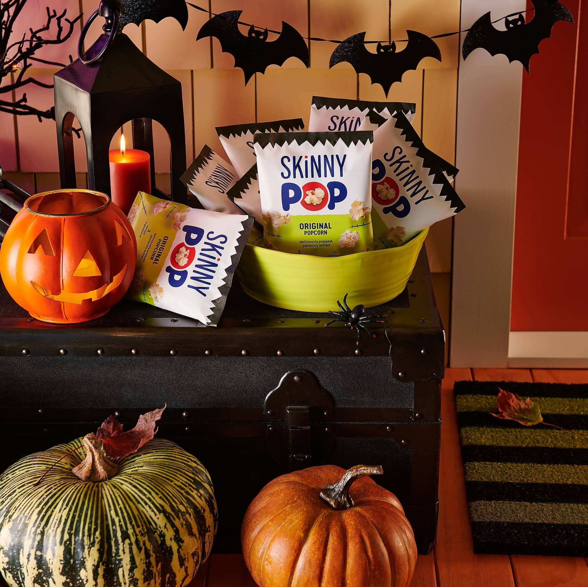 SkinnyPop Family Favorite Variety Pack in a festive bowl for Halloween snacks with pumpkins and bats.